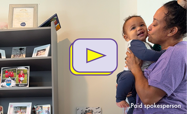 The thumbnail image for a video showing a woman holding her baby and kissing the baby's cheek. A yellow and purple play button is visible.